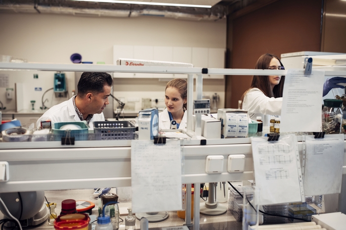 A photo of 2 students working in a lab